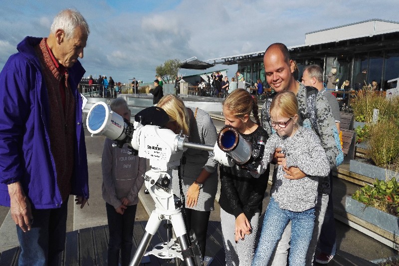 Uitleg aan een jong publiek bij de zonnekijkers op het dak van NEMO